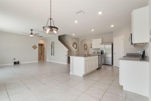 6808 Cranes Roost Rd, Harmony, FL 34773 - kitchen with stainless steel appliances, arched walkways, open floor plan, recessed lighting, and white cabinets