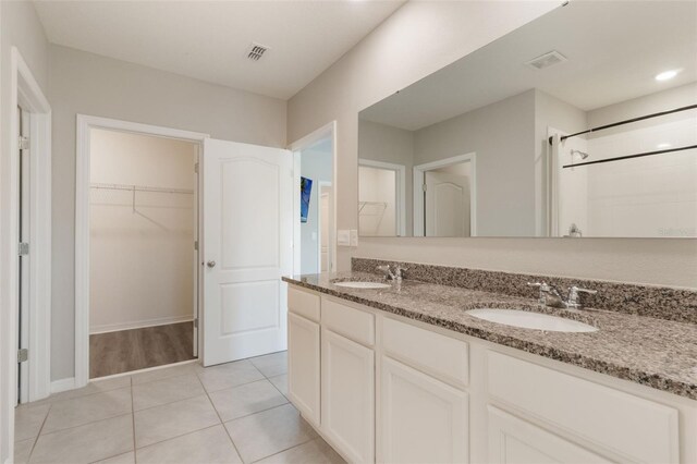 6808 Cranes Roost Rd, Harmony, FL 34773 - full bathroom with double vanity, a walk in closet, tile patterned flooring, and a shower
