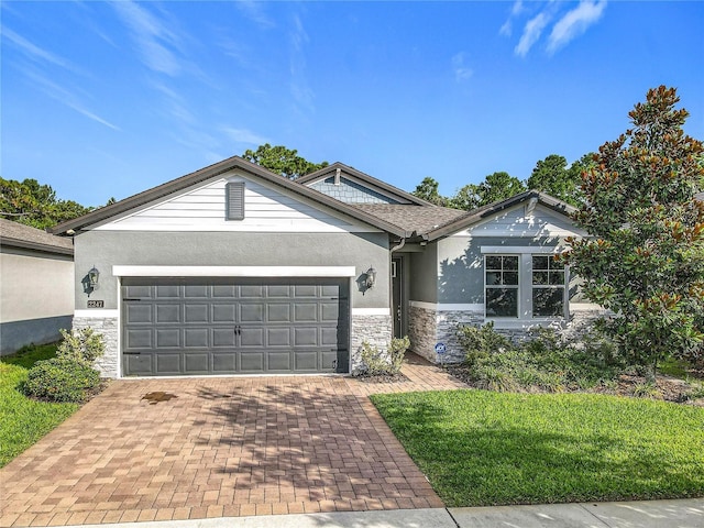 2247 Marsh Sedge Ln, Winter Park, FL 32792 - ranch-style home featuring stone siding, stucco siding, an attached garage, and decorative driveway