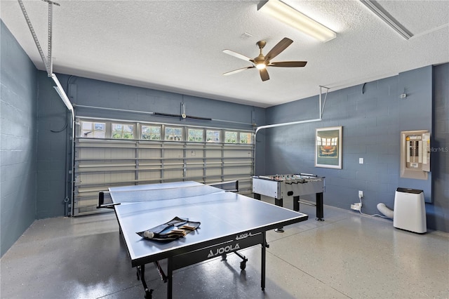 9023 Shadow Mountain St, Davenport, FL 33896 - game room featuring a garage, a textured ceiling, ceiling fan, concrete block wall, and electric panel