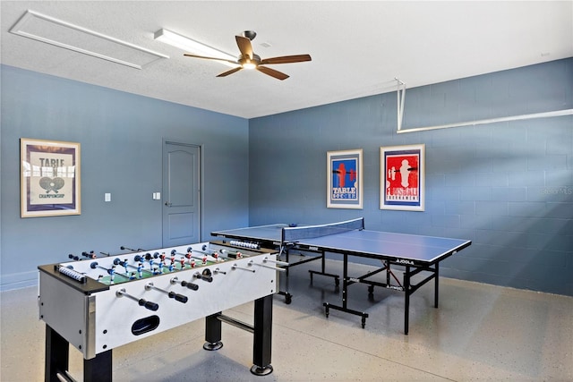9023 Shadow Mountain St, Davenport, FL 33896 - playroom featuring concrete block wall, ceiling fan, and speckle patterned floor