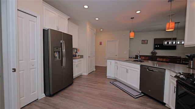 4858 Magnetite Loop, Mount Dora, FL 32757 - kitchen featuring stainless steel appliances, a peninsula, white cabinetry, light wood finished floors, and recessed lighting