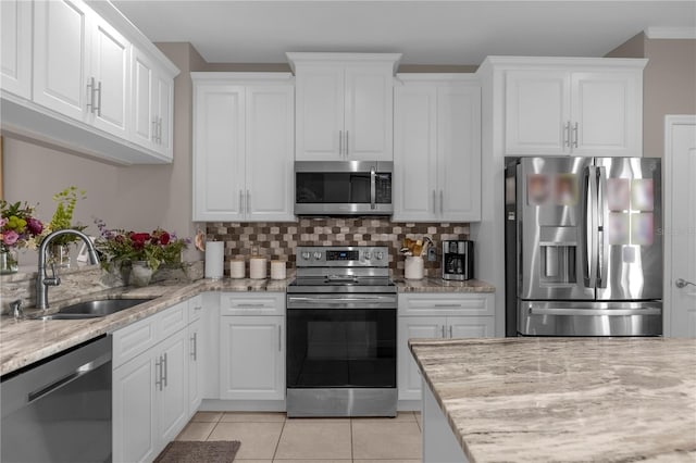 3508 Porta Romano Way, Lake Mary, FL 32746 - kitchen with stainless steel appliances, decorative backsplash, white cabinets, light stone counters, and light tile patterned floors