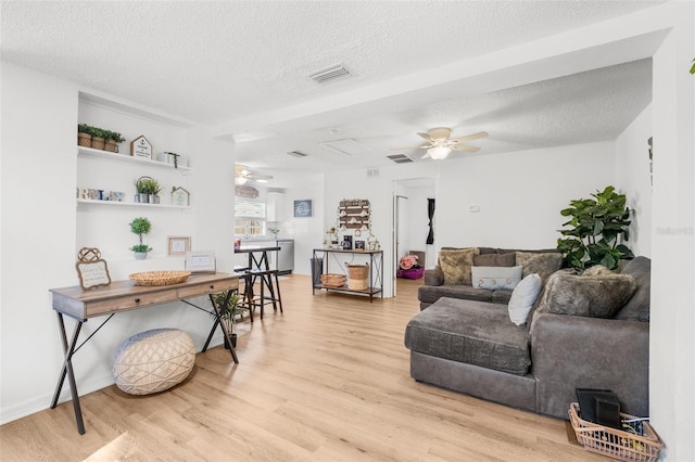 5141 Mallet Dr, Port Richey, FL 34668 - living room with ceiling fan, light wood-style flooring, and a textured ceiling