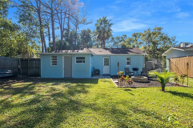 5141 Mallet Dr, Port Richey, FL 34668 - back of property with an outdoor fire pit, a fenced backyard, and stucco siding