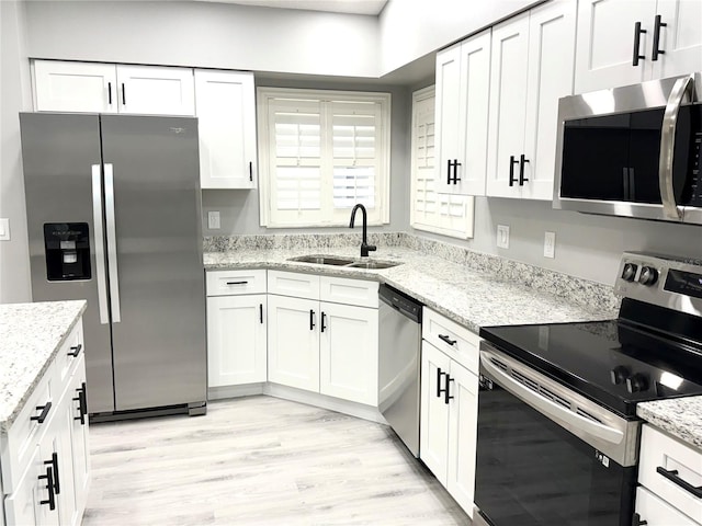 926 Freshmeadow Ct, Apopka, FL 32703 - kitchen featuring stainless steel appliances, white cabinetry, light wood-style flooring, and light stone countertops