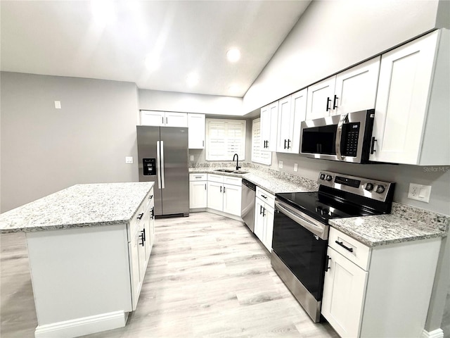 926 Freshmeadow Ct, Apopka, FL 32703 - kitchen featuring stainless steel appliances, a center island, white cabinets, lofted ceiling, and light stone counters