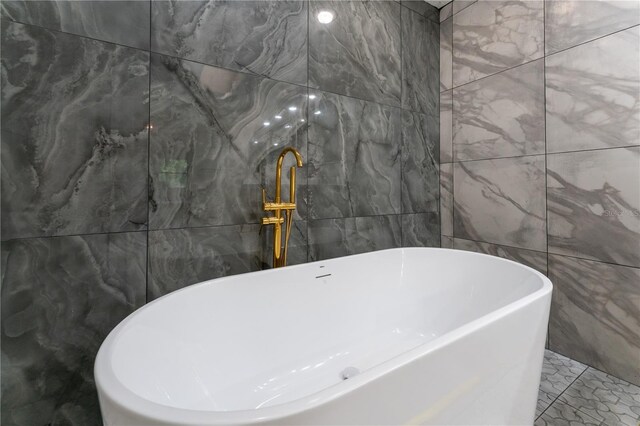 6019 Crystal View Dr, Orlando, FL 32819 - full bath with tile walls, a freestanding bath, and marble finish floors