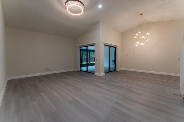 6019 Crystal View Dr, Orlando, FL 32819 - empty room featuring wood finished floors, a chandelier, high vaulted ceiling, and a textured ceiling