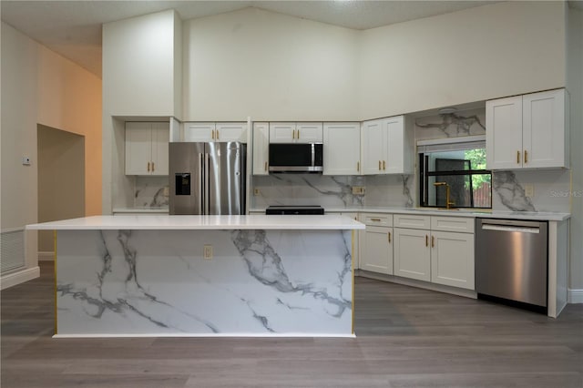 6019 Crystal View Dr, Orlando, FL 32819 - kitchen with stainless steel appliances, light countertops, backsplash, white cabinets, and high vaulted ceiling