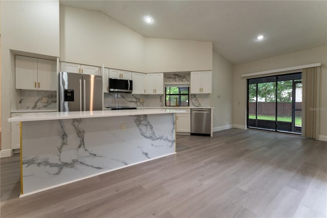 6019 Crystal View Dr, Orlando, FL 32819 - kitchen featuring appliances with stainless steel finishes, high vaulted ceiling, white cabinetry, wood finished floors, and recessed lighting