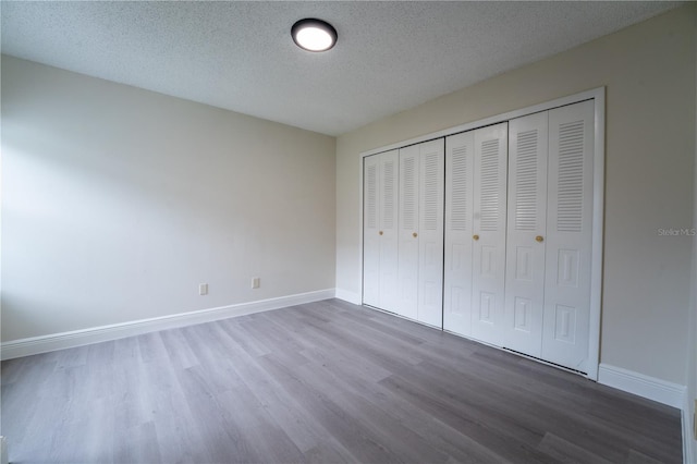 6019 Crystal View Dr, Orlando, FL 32819 - unfurnished bedroom with wood finished floors, a textured ceiling, and a closet