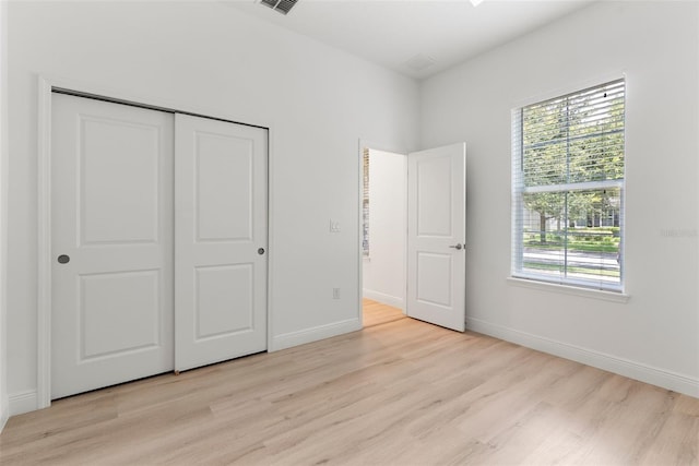 15448 Murcott Blossom Blvd, Winter Garden, FL 34787 - unfurnished bedroom with light wood-style flooring, multiple windows, and a closet