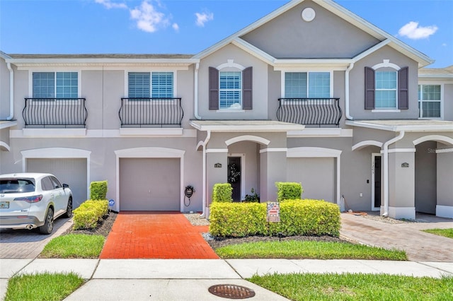 1191 Honey Blossom Dr Unit D, Orlando, FL 32824 - view of property with stucco siding, a garage, a balcony, and driveway