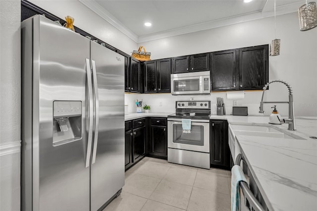 1191 Honey Blossom Dr Unit D, Orlando, FL 32824 - kitchen with stainless steel appliances, dark cabinetry, ornamental molding, light tile patterned floors, and light stone counters