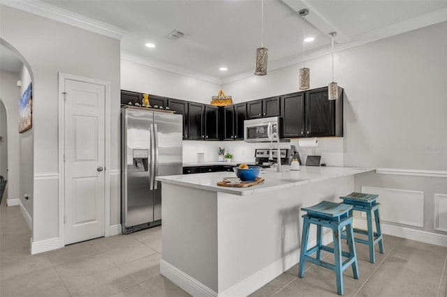 1191 Honey Blossom Dr Unit D, Orlando, FL 32824 - kitchen with appliances with stainless steel finishes, arched walkways, a peninsula, crown molding, and light countertops