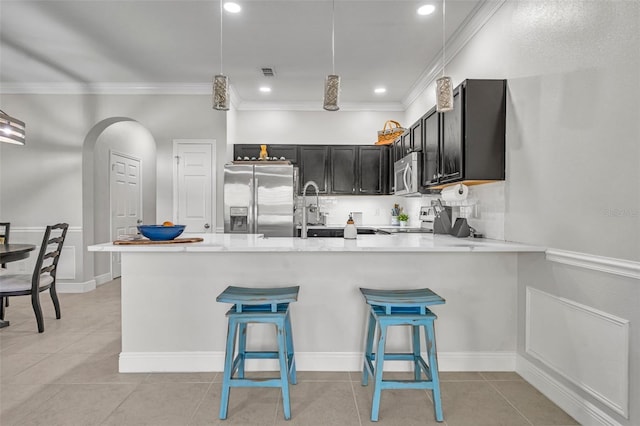 1191 Honey Blossom Dr Unit D, Orlando, FL 32824 - kitchen featuring stainless steel appliances, a peninsula, light countertops, crown molding, and light tile patterned flooring