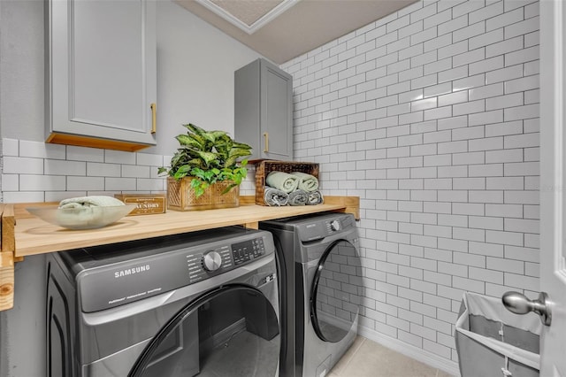 1191 Honey Blossom Dr Unit D, Orlando, FL 32824 - laundry area with washer and clothes dryer, cabinet space, ornamental molding, light tile patterned flooring, and tile walls