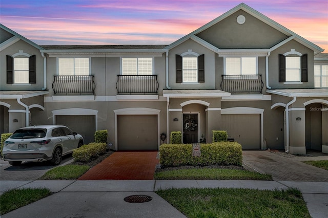 1191 Honey Blossom Dr Unit D, Orlando, FL 32824 - townhome / multi-family property featuring a balcony, stucco siding, a garage, and driveway