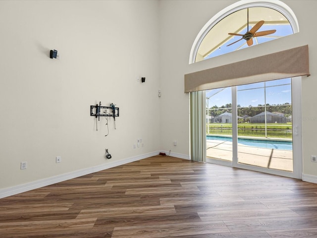 1111 Liberty Hall Dr, Kissimmee, FL 34746 - empty room featuring ceiling fan, wood finished floors, and a towering ceiling