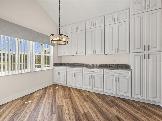1111 Liberty Hall Dr, Kissimmee, FL 34746 - unfurnished dining area with lofted ceiling, a chandelier, and wood finished floors
