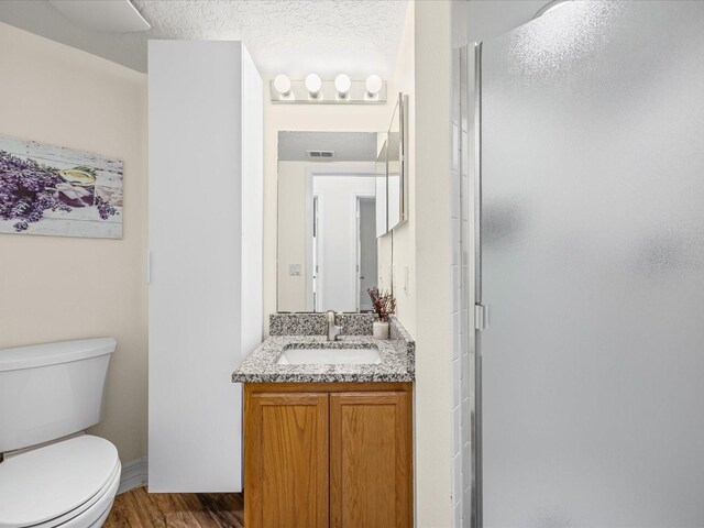 1111 Liberty Hall Dr, Kissimmee, FL 34746 - bathroom featuring vanity, a shower stall, wood finished floors, and a textured ceiling