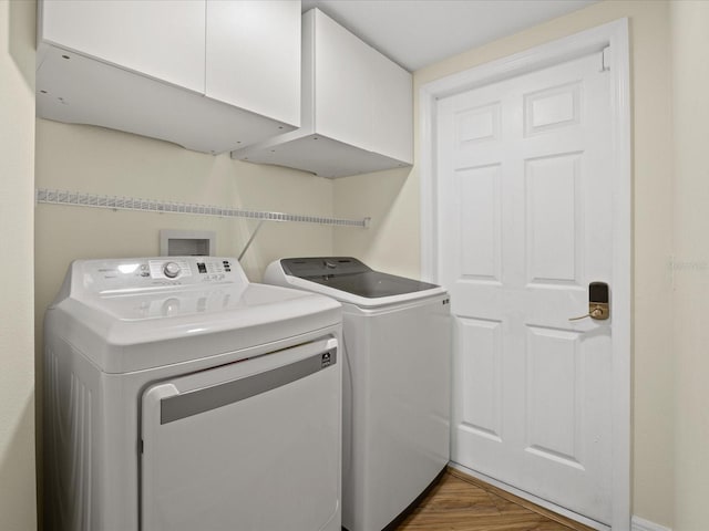 1111 Liberty Hall Dr, Kissimmee, FL 34746 - laundry room with cabinet space, washer and dryer, and wood finished floors