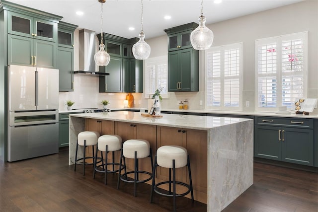 4310 Ethan Ln, Orlando, FL 32814 - kitchen with freestanding refrigerator, wall chimney exhaust hood, a kitchen island, dark wood-type flooring, and tasteful backsplash