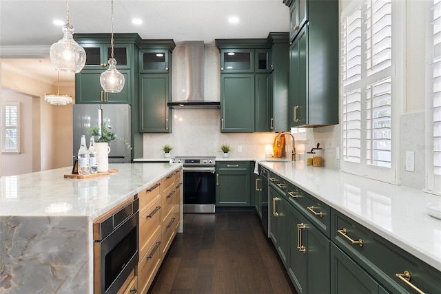 4310 Ethan Ln, Orlando, FL 32814 - kitchen featuring appliances with stainless steel finishes, wall chimney range hood, green cabinetry, crown molding, and dark wood finished floors