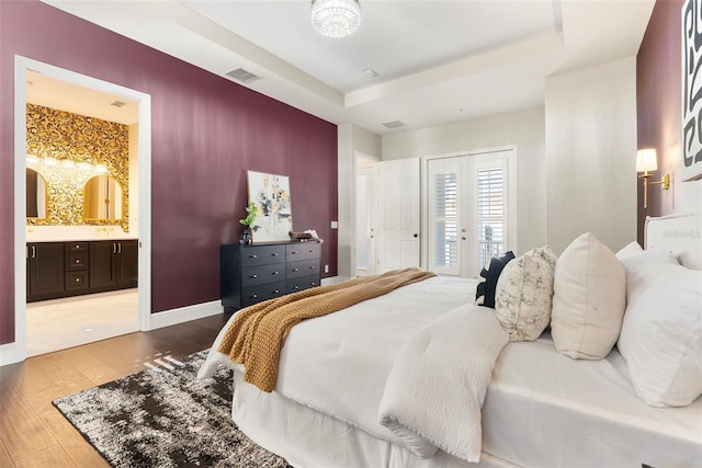 4310 Ethan Ln, Orlando, FL 32814 - bedroom with hardwood / wood-style flooring, a tray ceiling, ensuite bathroom, and access to exterior