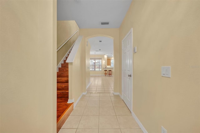 1534 Barking Deer Cv, Casselberry, FL 32707 - hallway featuring light tile patterned floors, arched walkways, and stairs