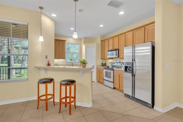 1534 Barking Deer Cv, Casselberry, FL 32707 - kitchen featuring appliances with stainless steel finishes, a breakfast bar area, light countertops, a peninsula, and recessed lighting