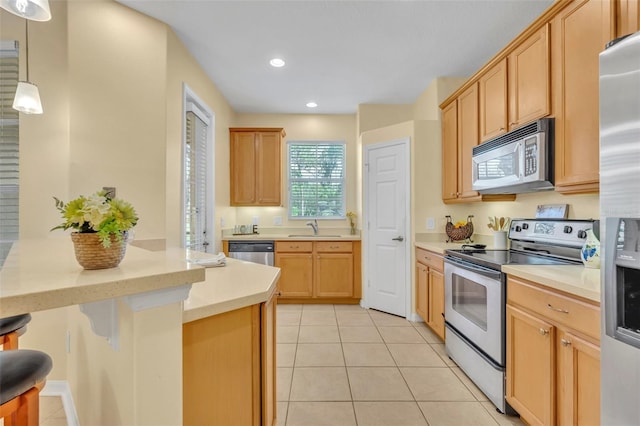 1534 Barking Deer Cv, Casselberry, FL 32707 - kitchen with appliances with stainless steel finishes, light countertops, light tile patterned floors, a breakfast bar, and recessed lighting