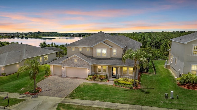 16412 Good Hearth Blvd, Clermont, FL 34711 - traditional home featuring a garage, decorative driveway, a water view, covered porch, and a front yard