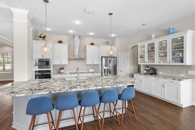 16412 Good Hearth Blvd, Clermont, FL 34711 - kitchen with stainless steel appliances, wall chimney exhaust hood, white cabinetry, backsplash, and recessed lighting