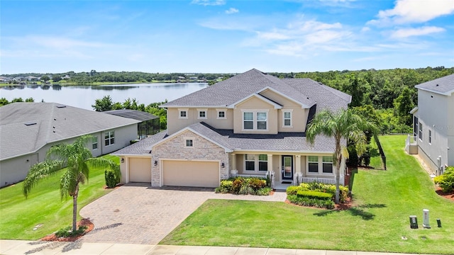 16412 Good Hearth Blvd, Clermont, FL 34711 - traditional-style house featuring covered porch, an attached garage, a water view, decorative driveway, and stucco siding
