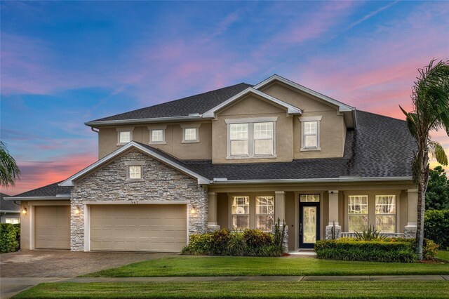 16412 Good Hearth Blvd, Clermont, FL 34711 - view of front of property featuring stucco siding, covered porch, stone siding, driveway, and a front yard