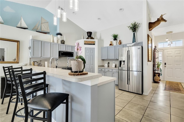 2919 Foraker Way, Kissimmee, FL 34758 - kitchen with stainless steel fridge with ice dispenser, black microwave, high vaulted ceiling, a peninsula, and light countertops