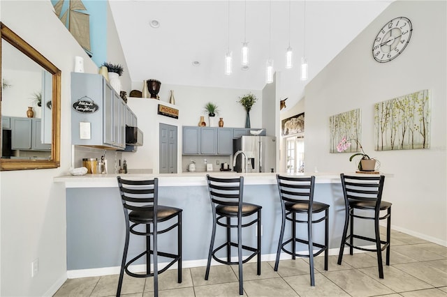 2919 Foraker Way, Kissimmee, FL 34758 - kitchen with stainless steel fridge with ice dispenser, high vaulted ceiling, a peninsula, light countertops, and a kitchen breakfast bar