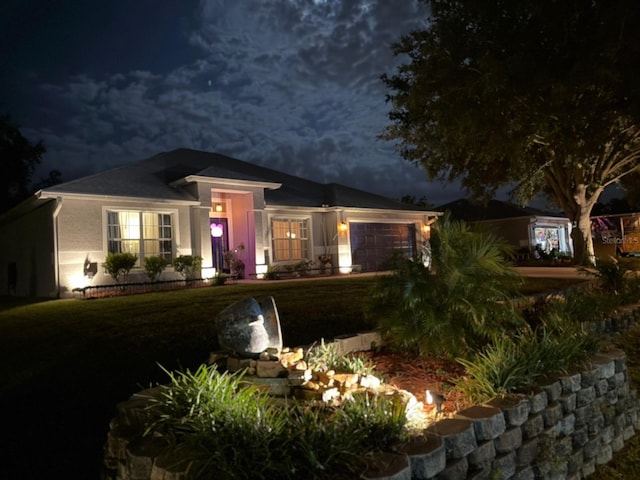 2919 Foraker Way, Kissimmee, FL 34758 - view of front of property with a garage, a yard, and stucco siding
