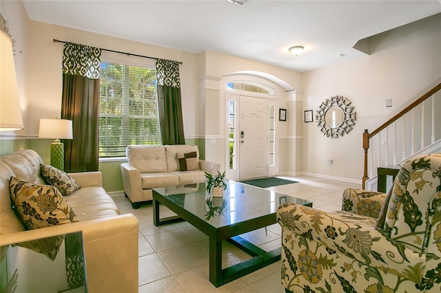 2669 Manesty Ln, Kissimmee, FL 34747 - living area with light tile patterned floors, healthy amount of natural light, and stairs