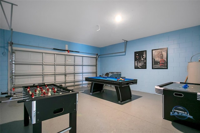 2669 Manesty Ln, Kissimmee, FL 34747 - recreation room with concrete block wall, water heater, and a garage