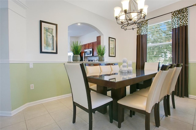 2669 Manesty Ln, Kissimmee, FL 34747 - dining area featuring arched walkways, a chandelier, and light tile patterned flooring