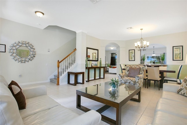 2669 Manesty Ln, Kissimmee, FL 34747 - living room featuring arched walkways, light tile patterned floors, a chandelier, stairway, and decorative columns