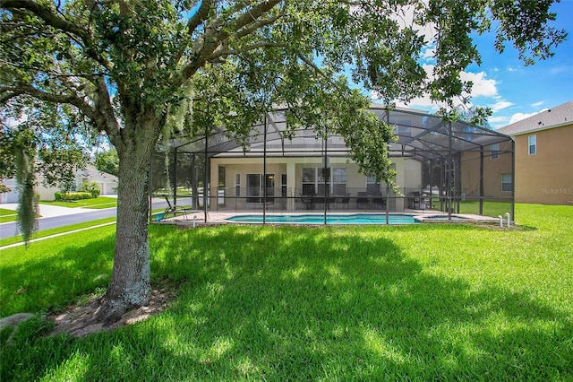 2669 Manesty Ln, Kissimmee, FL 34747 - rear view of house with a lawn, a lanai, and an outdoor pool