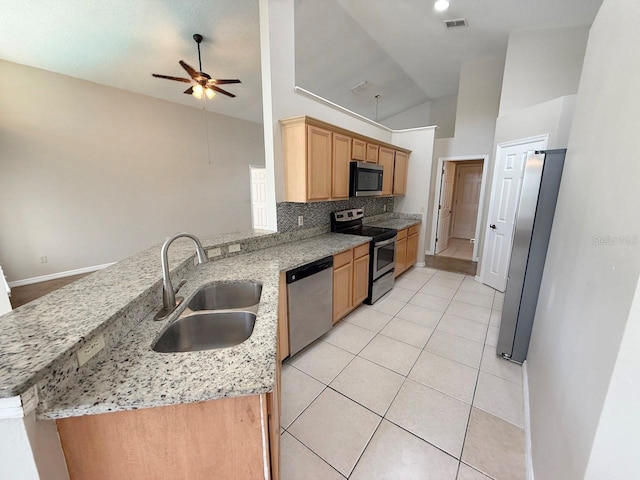 kitchen featuring stainless steel appliances, a peninsula, ceiling fan, vaulted ceiling, and light tile patterned floors