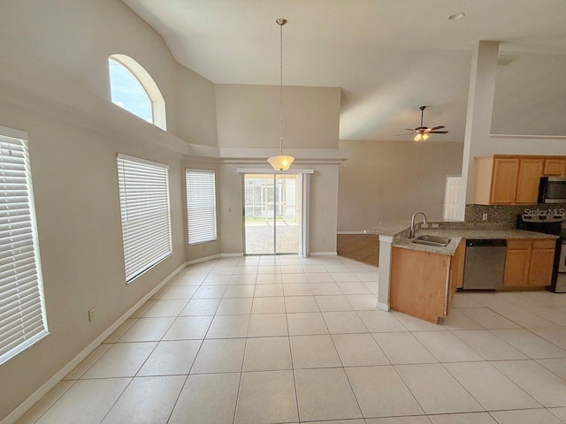 kitchen with stainless steel appliances, high vaulted ceiling, a peninsula, open floor plan, and healthy amount of natural light