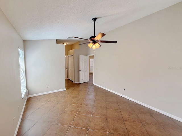 spare room featuring ceiling fan, a textured ceiling, and tile patterned flooring
