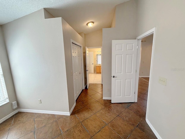 hallway featuring tile patterned flooring and a textured ceiling