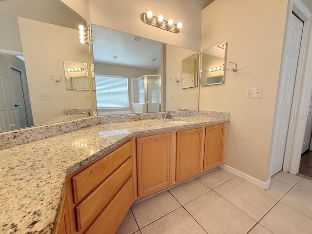 bathroom with tile patterned flooring, double vanity, and a stall shower